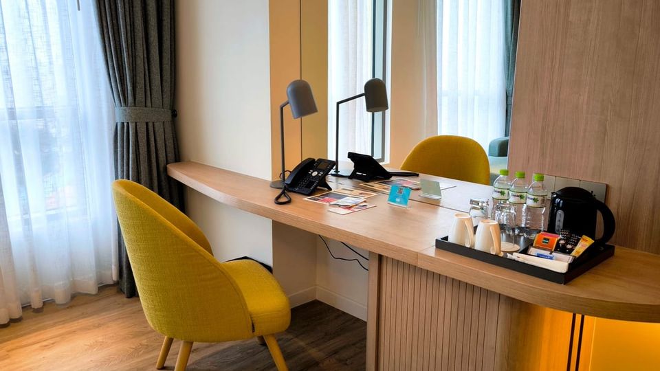 Hotel room desk with a lamp and chairs
