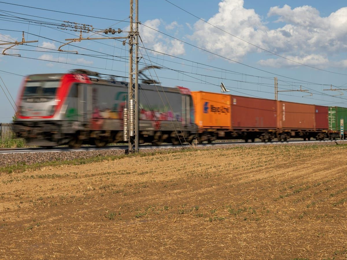 Freight train with containers passing a field